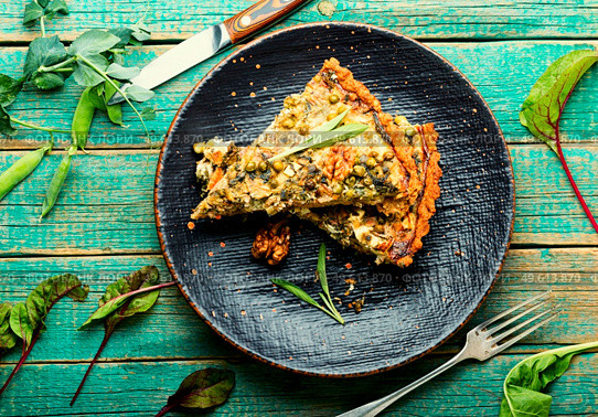 Rural pie with swiss chard, feta cheese and green peas. Pie with herbs on rustic wooden background. Open pie with herbs and green peas. Стоковое фото, агентство Ingram Publishing / Фотобанк Лори