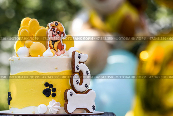Russia, Moscow, 28 June 2024: Birthday cake at the children's birthday party "Puppy Patrol". Balloons in the background. The concept of a children's holiday in nature. Редакционное фото, фотограф Photojuli / Фотобанк Лори