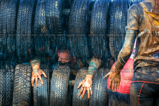 Russia, Samara, June 2019: athletic youth participates in a race of heroes and overcomes obstacles car tires on a summer day in the village of Roshchinsky . Text in Russian: race of heroes, platoon. Стоковое фото, фотограф Акиньшин Владимир / Фотобанк Лори