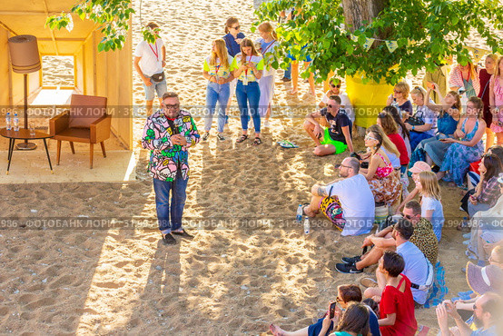 Russia, Samara, June 2019: Lecture by fashion historian Alexander Vasilyev outdoors. Bank of the Volga. Festival "Volga Fest" Редакционное фото, фотограф Акиньшин Владимир / Фотобанк Лори