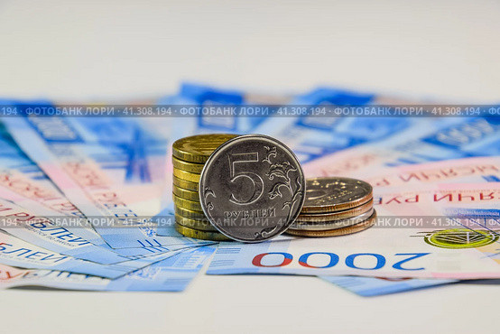 Russian banknotes and coins. A handful of coins on new Russian banknotes in denominations of 2000 and 200 rubles. Стоковое фото, фотограф Леонид Еремейчук / Фотобанк Лори