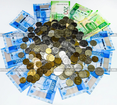 Russian banknotes and coins. A handful of coins on new Russian banknotes in denominations of 2000 and 200 rubles. Стоковое фото, фотограф Леонид Еремейчук / Фотобанк Лори