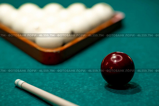 Russian billiards. Red and white balls are lying on a green billiard table. Spending time at home playing a hobby sports game. Стоковое фото, фотограф Photojuli / Фотобанк Лори