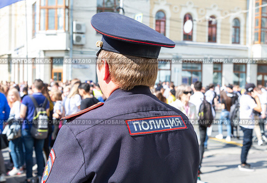 Russian police officer against the crowd at the city street. Text in russian: police (2019 год). Редакционное фото, фотограф FotograFF / Фотобанк Лори