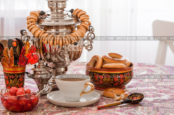 Русские традиции. Чаепитие с самоваром. Натюрморт с чашкой чая, рогаликами, бубликами, яблочным вареньем, леденцом петушок и русскими самоварами. Стоковое фото, фотограф Photojuli / Фотобанк Лори