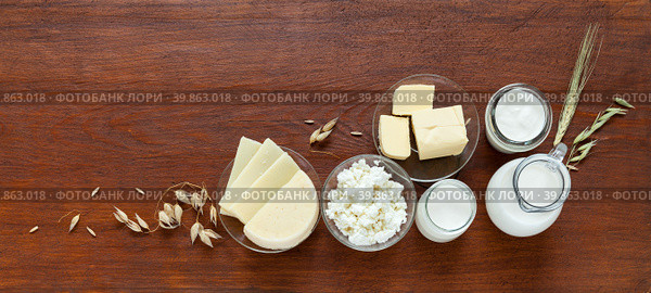 Rustic still life with fresh dairy products - milk, cottage cheese, yogurt, sour cream, butter and oat ears on old wooden table. Organic farm natural food. Place for text. Banner. Flat lay, copy space, mock up. Стоковое фото, фотограф Виктория Катьянова / Фотобанк Лори
