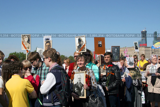 С фотографий увядших глядят... Люди на акции "Бессмертный полк". Москва, Поклонная гора, День Победы (2014 год). Редакционное фото, фотограф Щеголева Ольга / Фотобанк Лори