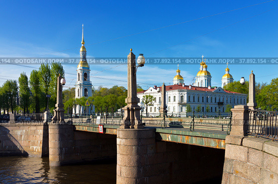 Saint Petersburg. Place of the Seven Bridges. View from the Pikalov Bridge Embankment on the Nikolsky Naval Cathedral Belltower on a spring day  (Nikolskiy Morskoy Sobor). The name of the bridge Pikalov Bridge is written on a blue index (2018 год). Стоковое фото, фотограф Виктория Катьянова / Фотобанк Лори