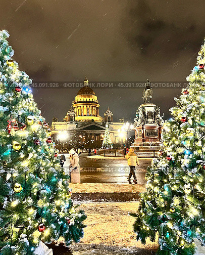 SAINT PETERSBURG, RUSSIA -December 25, 2023: Christmas and New Year holidays in Petersburg. People walking along St. Isaac's Square decorated with Christmas trees on winter evening. Редакционное фото, фотограф Виктория Катьянова / Фотобанк Лори