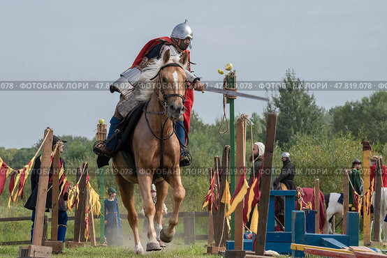 SAINT PETERSBURG, RUSSIA - SEPTEMBER 14, 2024: A warrior in medieval Russian armor chops an apple while galloping. Demonstration performances of the historical reconstruction club at the city festival "Spirit of Time" Редакционное фото, фотограф Виктор Карасев / Фотобанк Лори