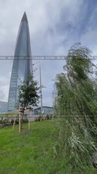 SAINT PETERSBURG, RUSSIA - September 27, 2024: Vertical video from new East Park with green trees to the 87 - story skyscraper Lakhta Center - popular city landmark and tourists attraction. Редакционное видео, видеограф Виктория Катьянова / Фотобанк Лори