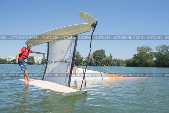 salior trying to right his catamaran after capsize. Стоковое фото, агентство Ingram Publishing / Фотобанк Лори