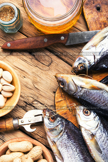 salted fish and beer. glass of beer, salted fish and nuts on a wooden table. Стоковое фото, агентство Ingram Publishing / Фотобанк Лори