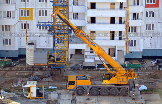 Самоходный подъемный кран повышенной проходимости Liebherr LTM 1100-5.2 компании "Вертикаль" на строительстве нового многоэтажного панельного жилого дома (2015 год). Редакционное фото, фотограф Александр Замараев / Фотобанк Лори