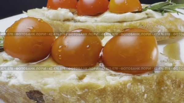 Sandwiches with cottage cheese and cucumber slices, cherry tomatoes on a white farm baguette on a wooden table. Close-up shooting. Стоковое видео, видеограф Ярославский Максим / Фотобанк Лори