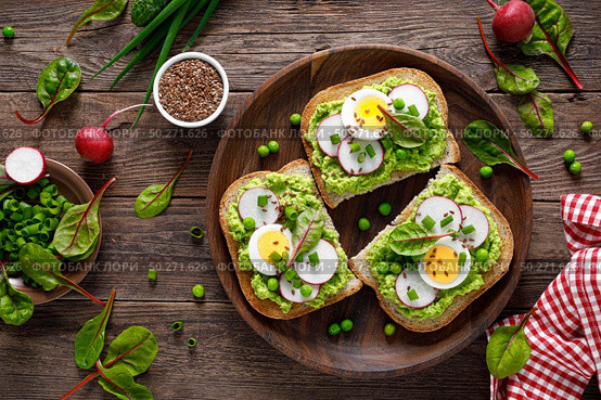Sandwiches with wholemeal bread, hummus or puree of fresh green peas, radish, cucumber, boiled egg, green onion and chard. Стоковое фото, агентство Ingram Publishing / Фотобанк Лори