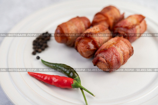 Sausage wrapped pork belly on a white plate. Selective focus. Стоковое фото, агентство Ingram Publishing / Фотобанк Лори