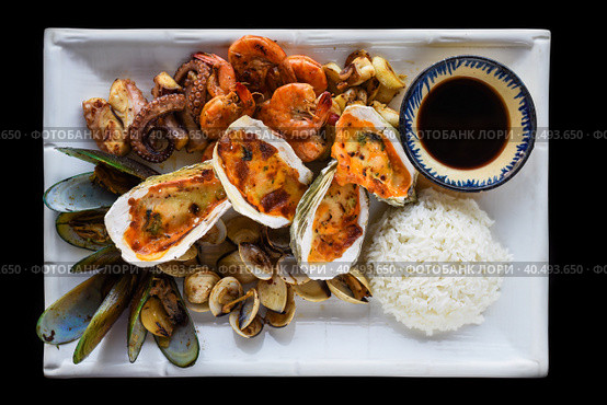 Sautéed seafood on white plate close up isolated on black background top view. Стоковое фото, фотограф Татьяна Терехина / Фотобанк Лори