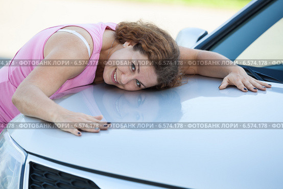 Счастливая девушка прижимается к капоту автомобиля. Стоковое фото, фотограф Кекяляйнен Андрей / Фотобанк Лори