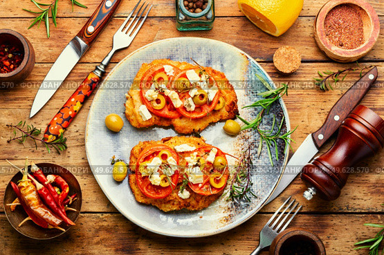Schnitzel, breaded and fried thin layer of meat. Austrian dish. Schnitzel with olives and tomato. Стоковое фото, агентство Ingram Publishing / Фотобанк Лори
