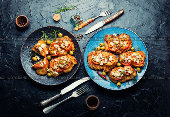 Schnitzel, breaded and fried thin layer of meat. Cretan schnitzel.. Fried schnitzel with olives and tomato. Стоковое фото, агентство Ingram Publishing / Фотобанк Лори
