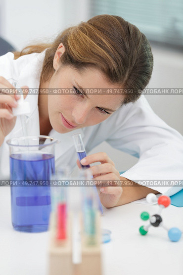 scientist holding 50 ml conical tube with blue liquid solution. Стоковое фото, агентство Ingram Publishing / Фотобанк Лори