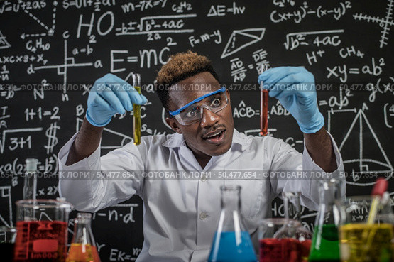 Scientists startled at the orange chemical in the glass at the laboratory. Стоковое фото, агентство Ingram Publishing / Фотобанк Лори