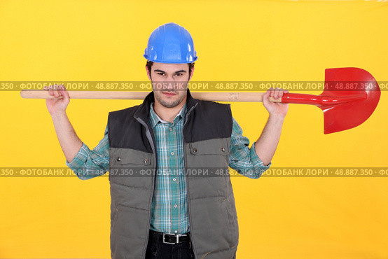 Scowling labourer carrying a shovel. Стоковое фото, агентство Ingram Publishing / Фотобанк Лори