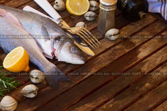 Seabass. Two Seabass raw fish on wooden table  with copy space. Стоковое фото, агентство Ingram Publishing / Фотобанк Лори