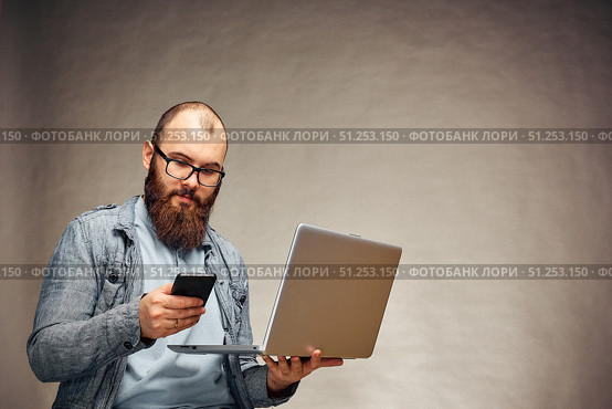 secure online payments. two factor authorization. man hands holding mobile phone and entering password message on laptop. Стоковое фото, фотограф Арзюков Вадим Николаевич / Фотобанк Лори