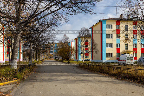 Село Клёпка, Магаданская область, Россия. Вид на улицу и красочные здания в северном посёлке. Осенний сезон. Сентябрь. Опавшие листья на дороге. Путешествие в Сибирь и на Дальний Восток России. Редакционное фото, фотограф Андрей Степанов / Фотобанк Лори