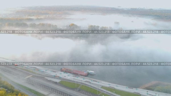 Съемка с беспилотника густого белого тумана над городской набережной реки Белая в Уфе. Осенний лес и пустая утренняя дорога (2022 год). Стоковое видео, видеограф Юлия Ильина / Фотобанк Лори