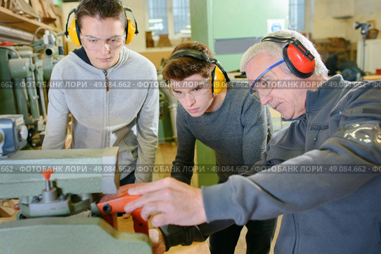 Senior carpenter with two learners. Стоковое фото, агентство Ingram Publishing / Фотобанк Лори