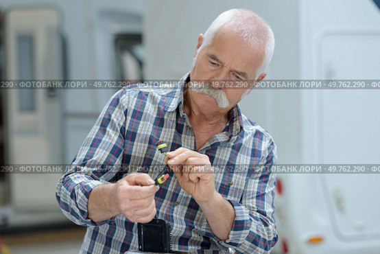 senior man fixing a campervan. Стоковое фото, агентство Ingram Publishing / Фотобанк Лори