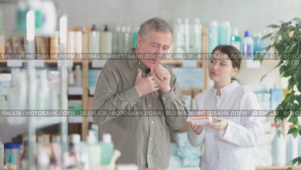 Senior man visits pharmacy and suffers from cough. Girl pharmacist offer help to sick customer. Стоковое видео, видеограф Яков Филимонов / Фотобанк Лори