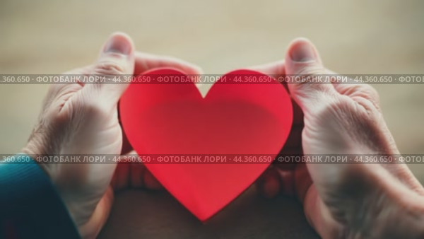 Senior woman holding red heart in her hands. Стоковое AI-видео, аниматор Юрий Поздников / Фотобанк Лори