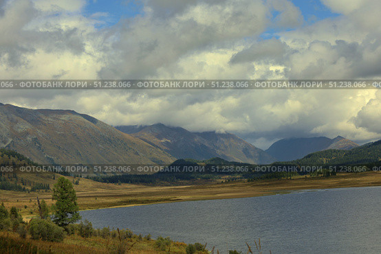 Serene Mountain Lake Landscape under Dramatic Cloudy Sky. Стоковое фото, фотограф Igor Bastrakov / Фотобанк Лори