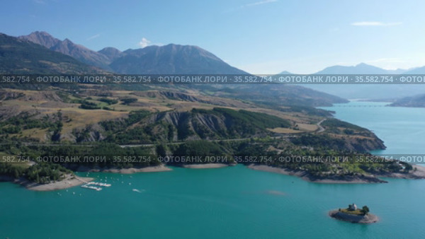 Serene summer landscape of Lake Serre-Poncon, artificial lake surrounded by French Alps, Provence-Alpes-Cote d Azur region. Стоковое видео, видеограф Яков Филимонов / Фотобанк Лори