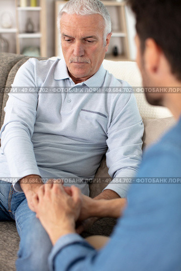 serious elderly father and grown-up adult son helping him. Стоковое фото, агентство Ingram Publishing / Фотобанк Лори