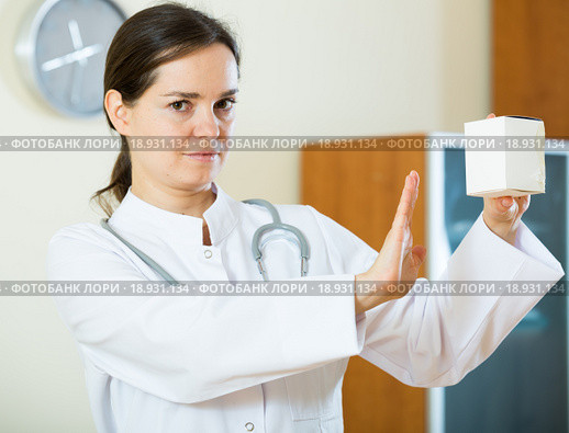 Serious female physician warning of faulty drugs. Стоковое фото, фотограф Яков Филимонов / Фотобанк Лори