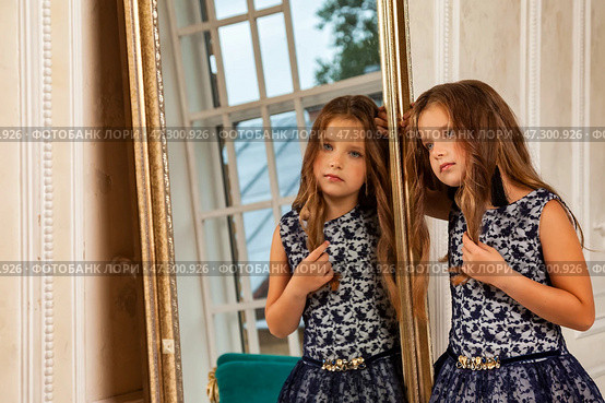 Seven-year-old Girl Model Poses in Stylish Outfit While Reflecting on Her Beauty in the Mirror. Стоковое фото, фотограф Aleksandr Golubev / Фотобанк Лори
