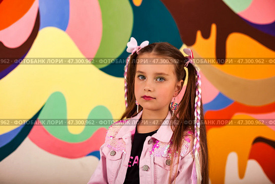 Seven Year Old Girl Model Poses in Vibrant Setting With Colorful Backdrop and Stylish Attire. Стоковое фото, фотограф Aleksandr Golubev / Фотобанк Лори