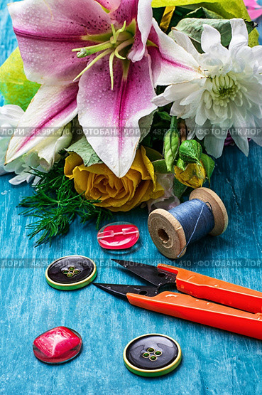 sewing accessories with a bouquet of fresh flowers on turquoise background. Стоковое фото, агентство Ingram Publishing / Фотобанк Лори