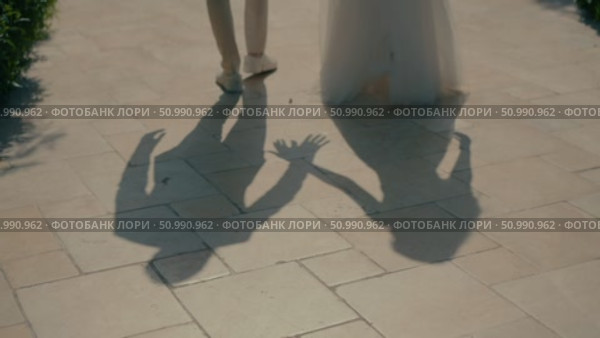 Shadow of a bride and groom holding hands. Стоковое видео, видеограф Tatiana Malinsky / Фотобанк Лори