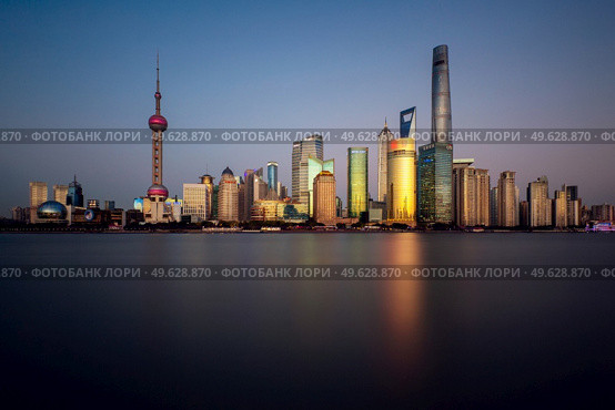 Shanghai - November 15, 2019 : Lujiazui skyline, as seen from the Bund, across the Huangpu River, the tallest building being Shanghai Tower. The Lujiazui district is the commercial and financial center of Shanghai.. Lujiazui skyline and Huangpu river, Shanghai, China. Редакционное фото, агентство Ingram Publishing / Фотобанк Лори