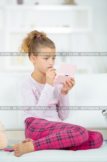 she is playing nintendo ds. Стоковое фото, агентство Ingram Publishing / Фотобанк Лори