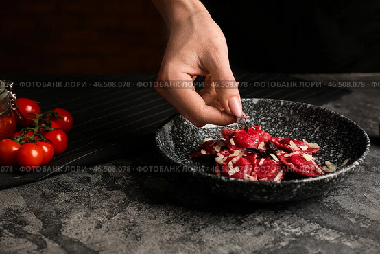 Шеф-повар добавляет травы к вкусным равиолям на тарелке. Стоковое фото, фотограф Pixel_shot / Фотобанк Лори