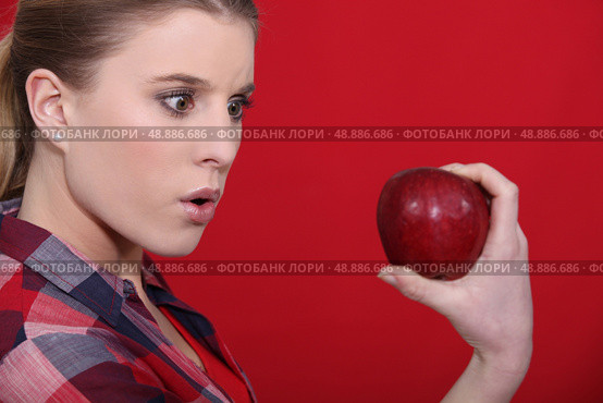 Shocked woman holding apple. Стоковое фото, агентство Ingram Publishing / Фотобанк Лори
