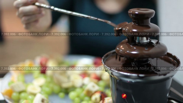 Шоколадный фонтан, человек ест фрукты с шоколадом. Стоковое видео, видеограф Кекяляйнен Андрей / Фотобанк Лори