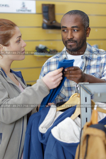 shop worker assisting customer looking at fleece jumers. Стоковое фото, агентство Ingram Publishing / Фотобанк Лори
